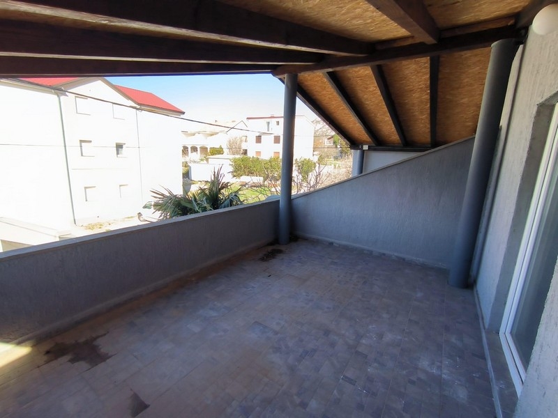 Zadaszony balkon z widokiem na dzielnicę mieszkaniową