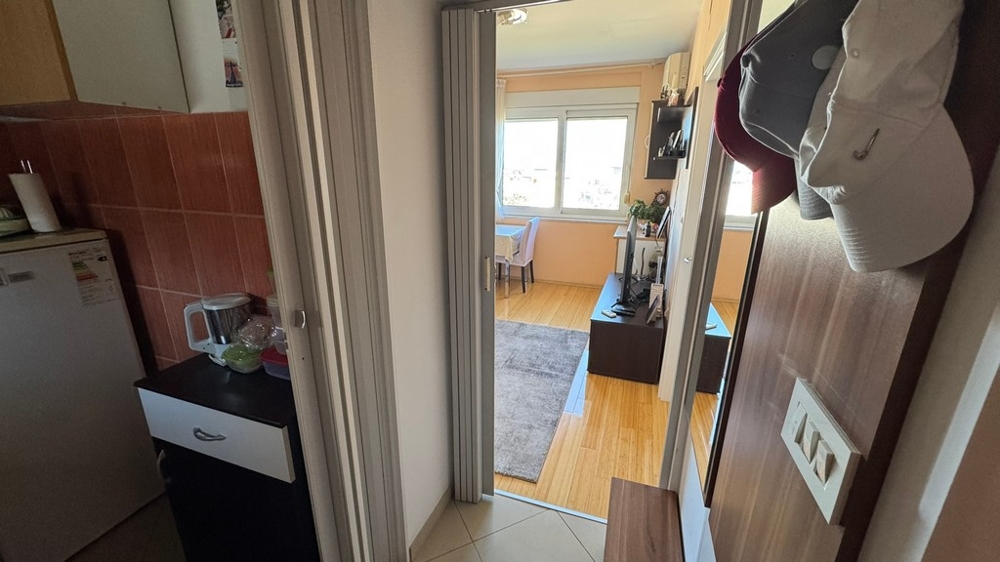 Strefa wejściowa z widokiem na salon i aneks kuchenny po lewej stronie