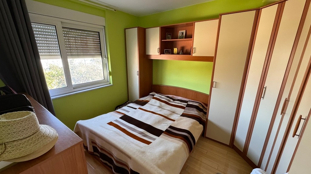 Sypialnia z podwójnym łóżkiem i wbudowanymi szafami, zielone ściany