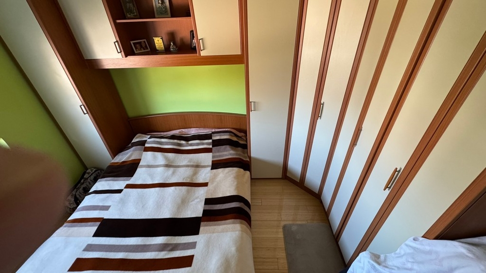 Sypialnia z szafą i schowkami nad łóżkiem