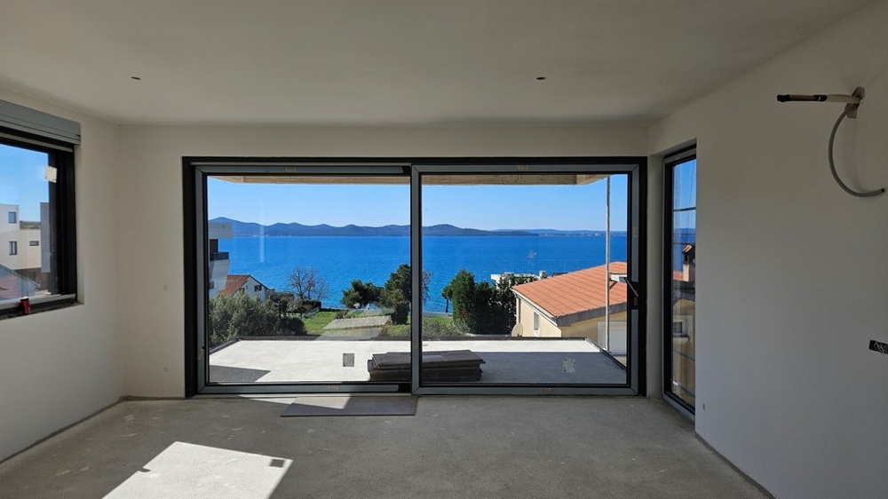 Widok na morze z salonu przez duży szklany front