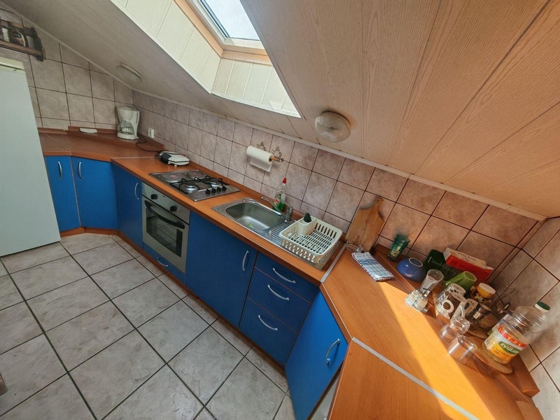 Kuchnia z niebieskimi frontami i świetlikiem