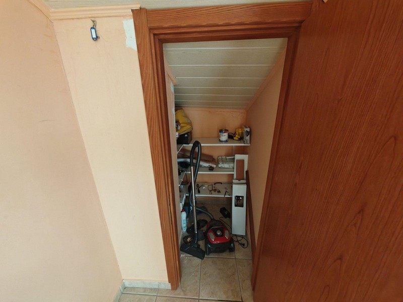 Mały schowek z półkami i odkurzaczem