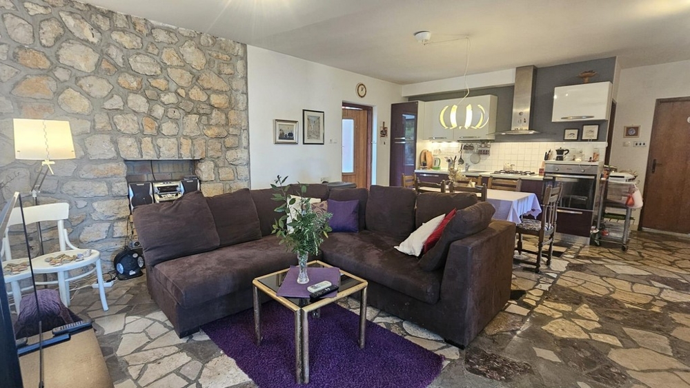 Część dzienna ze ścianą z kamienia naturalnego i kuchnią