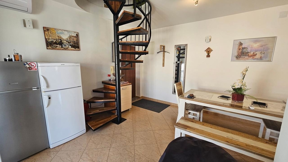 Część dzienna ze kręconymi schodami i lodówką