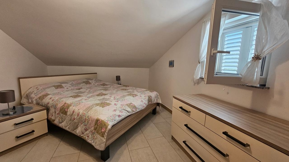 Sypialnia z podwójnym łóżkiem i komodą