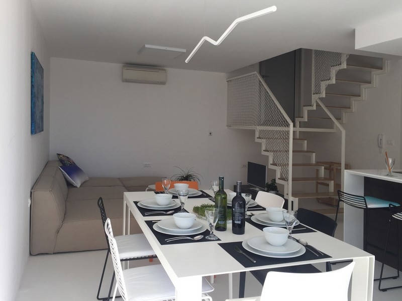 Pokój dzienny z sofą, jadalnią i schodami na galerię