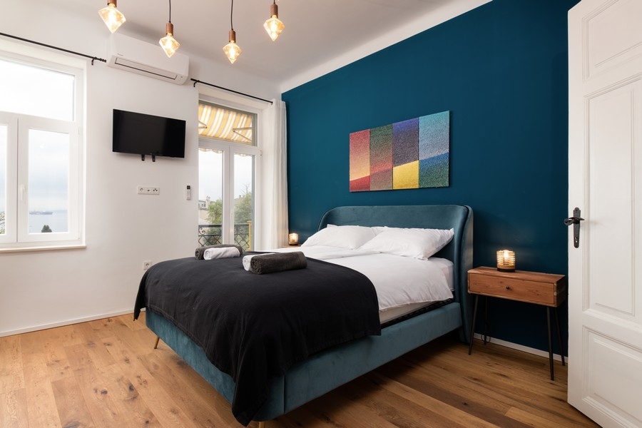 Sypialnia z widokiem na morze i ciemnoniebieską ścianą