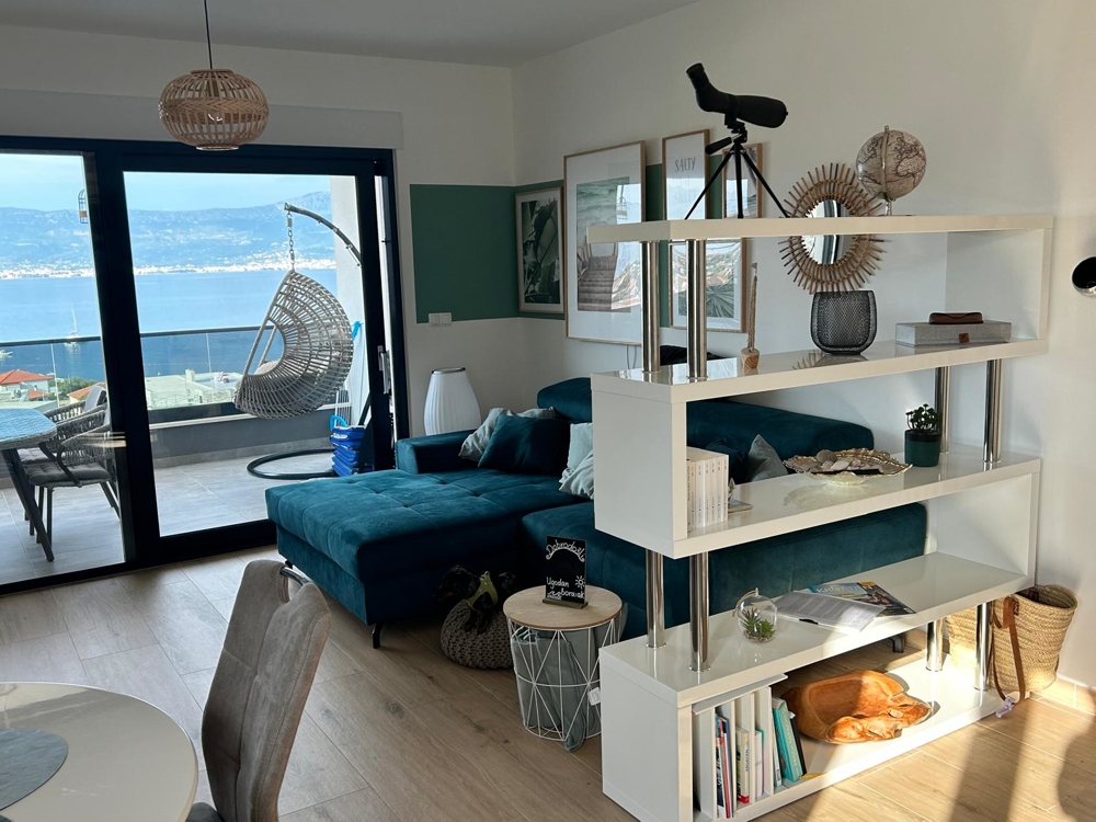 Pokój dzienny z widokiem na morze i wiszącym krzesłem