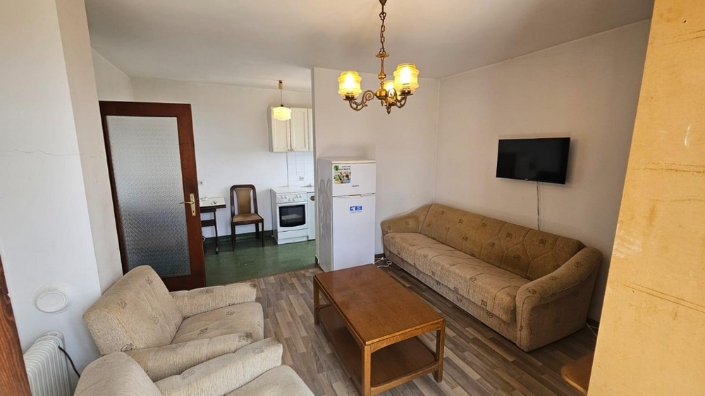 Część dzienna z sofą i widokiem na kuchnię