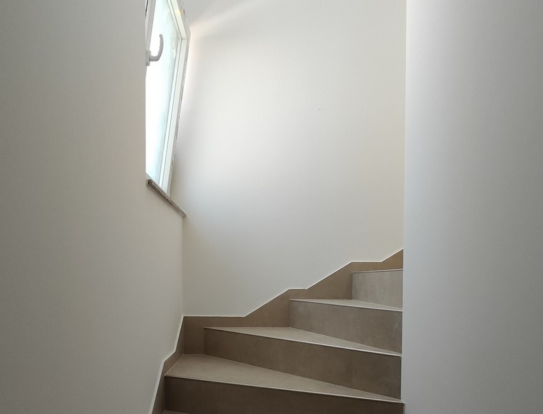 Jasne schody z oknami na klatce schodowej