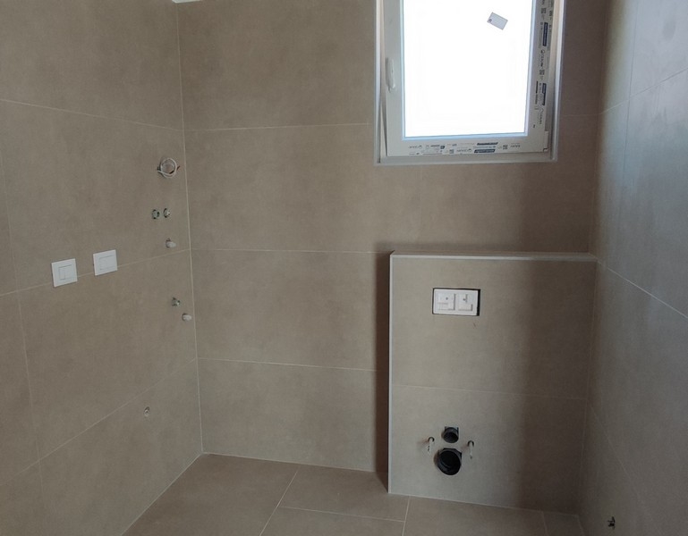 Nowoczesna łazienka w kafelkach z oknem i przyłączami