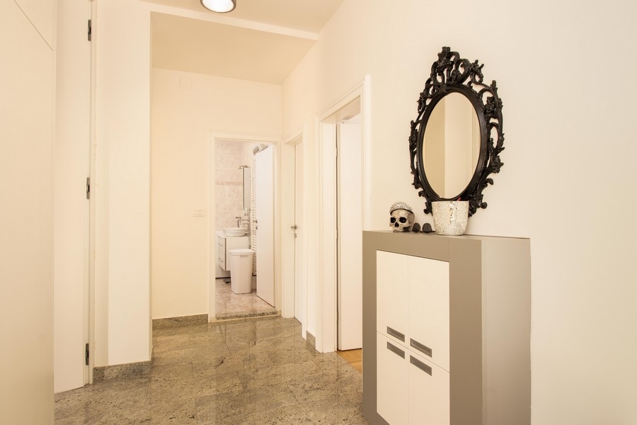 Przedpokój z szafką z lustrem i dostępem do łazienki