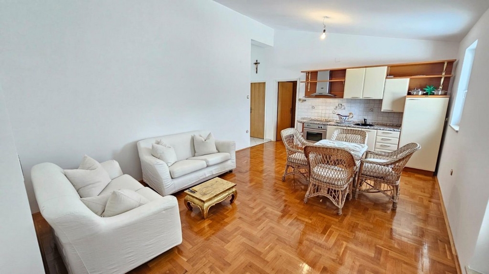 Część dzienna z sofą, rattanowymi krzesłami i kuchnią