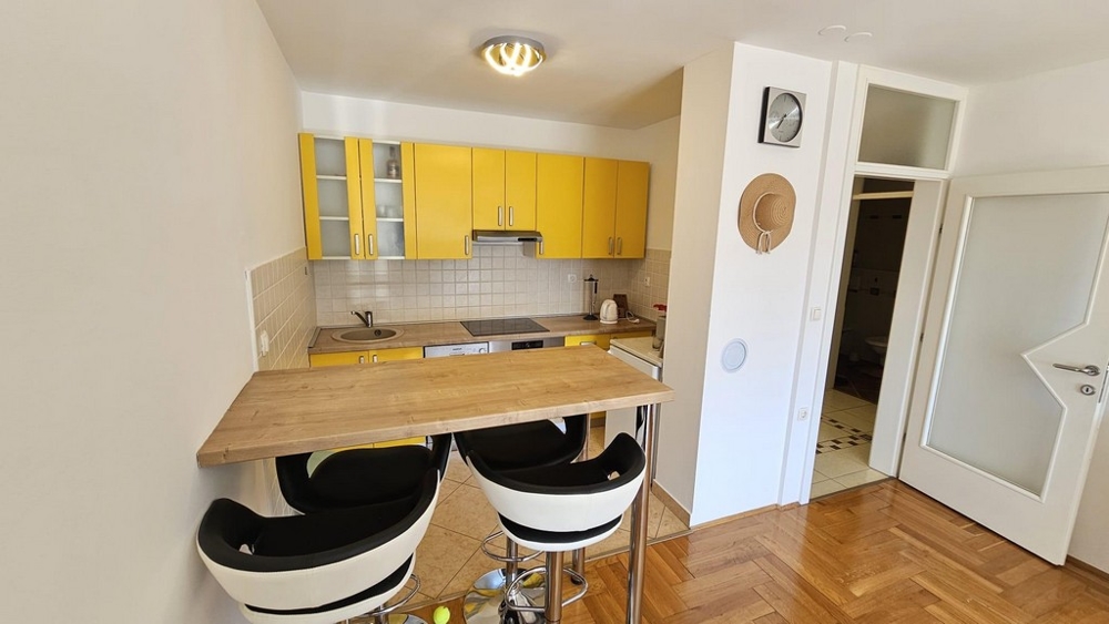Kuchnia z żółtymi wbudowanymi szafkami i ladą barową