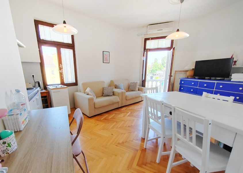 Jasny salon z sofą i stołem jadalnym