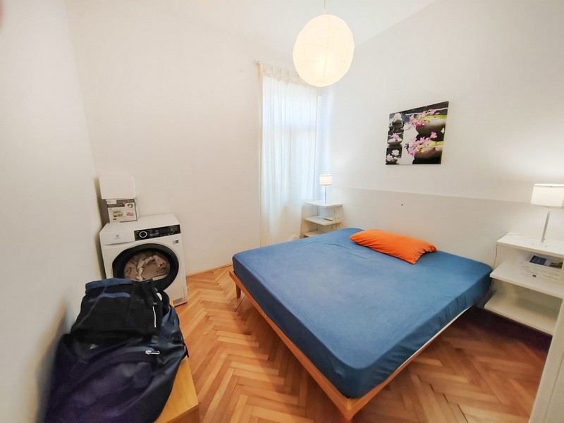 Sypialnia z podwójnym łóżkiem i pralką