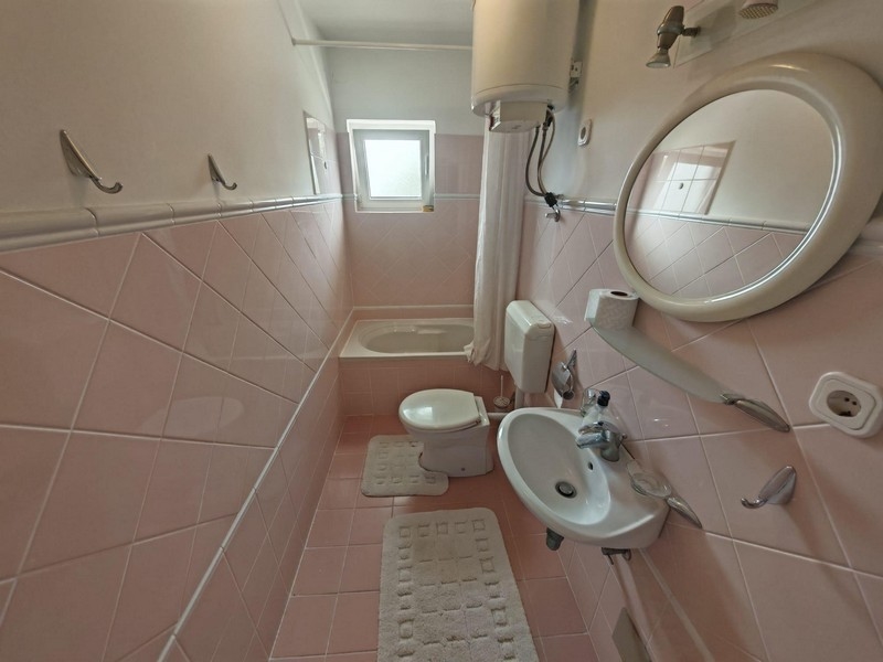 Łazienka z wanną i różowymi płytkami