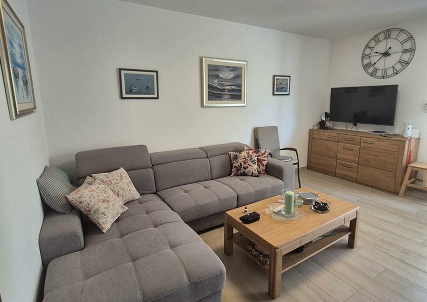 Część dzienna z szarą narożną sofą i stolikiem kawowym