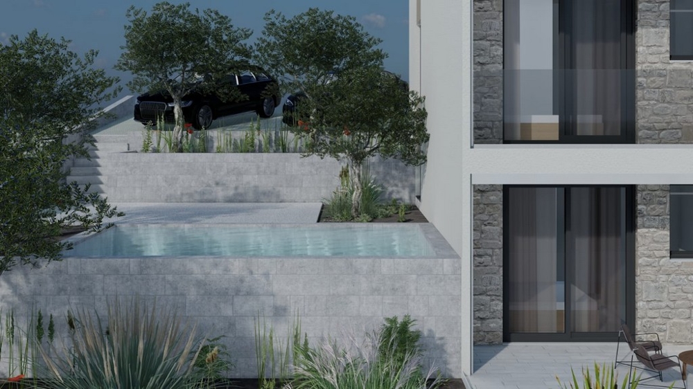 Basen przed budynkiem z zielenią i miejscami parkingowymi