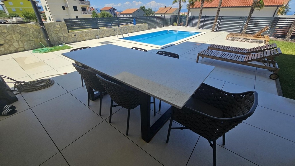 Taras ze stołem jadalnym, widokiem na basen i leżakami