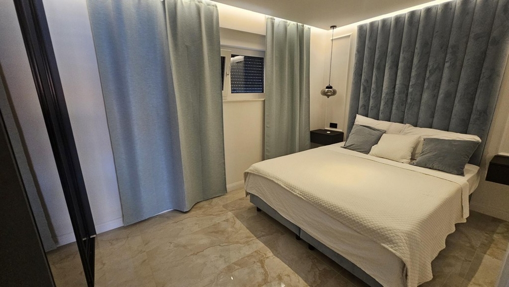 Sypialnia z podwójnym łóżkiem i bławymi zasłonami