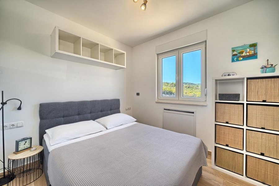 Jasna sypialnia z podwójnym łóżkiem i półkami