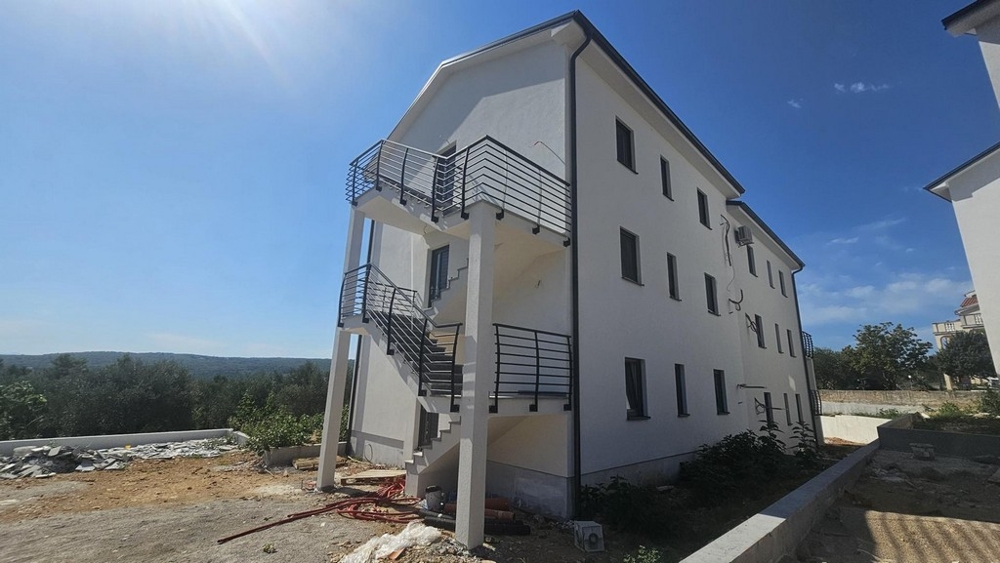 Tył nowego budynku ze schodami zewnętrznymi i otoczeniem w Soline