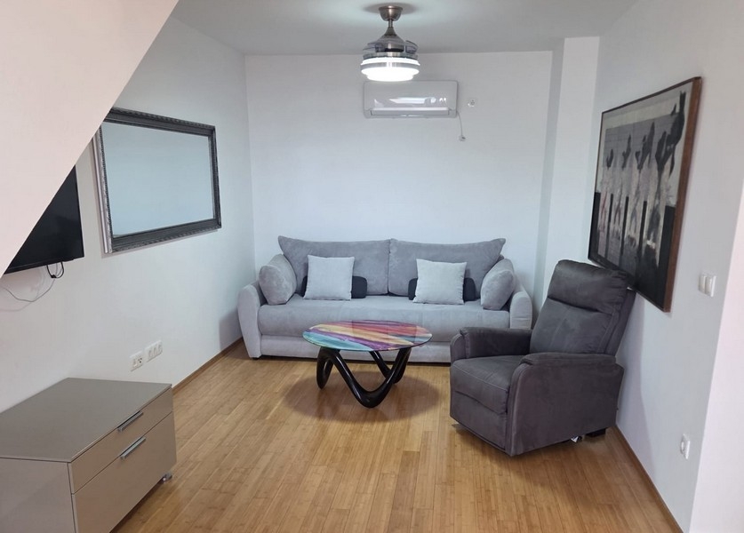 Pokój dzienny z sofą, fotelem i nowoczesnym stolikiem kawowym