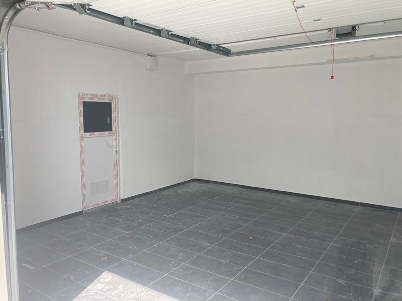 Garaż z podłogą wyłożoną płytkami i bocznymi drzwiami