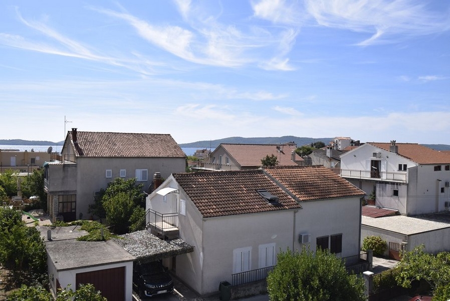 Widok z mieszkania na sąsiednie domy i morze