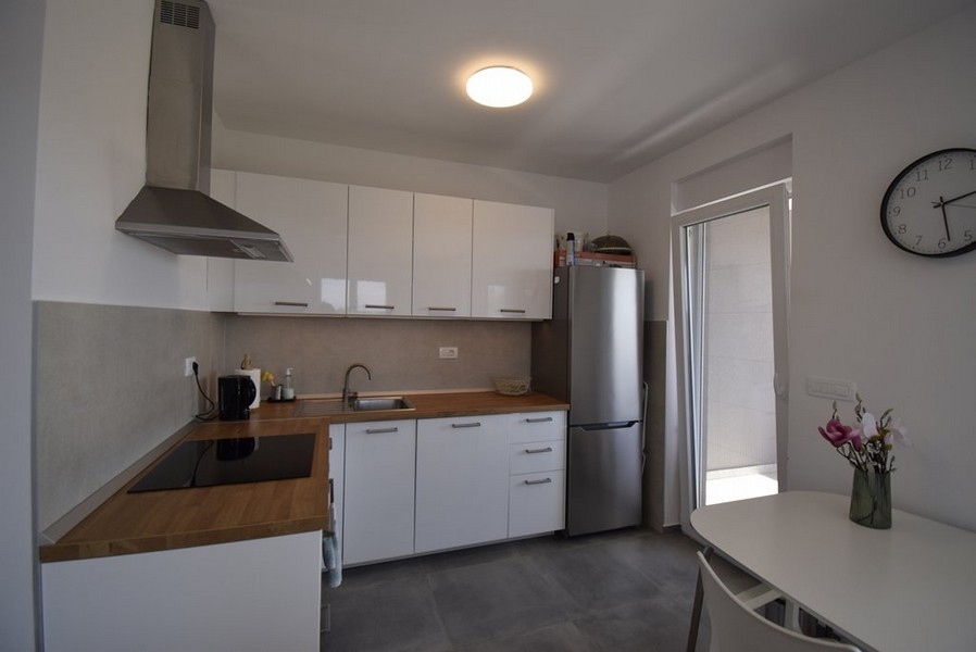 Nowoczesna kuchnia z zabudową AGD i stołem jadalnym