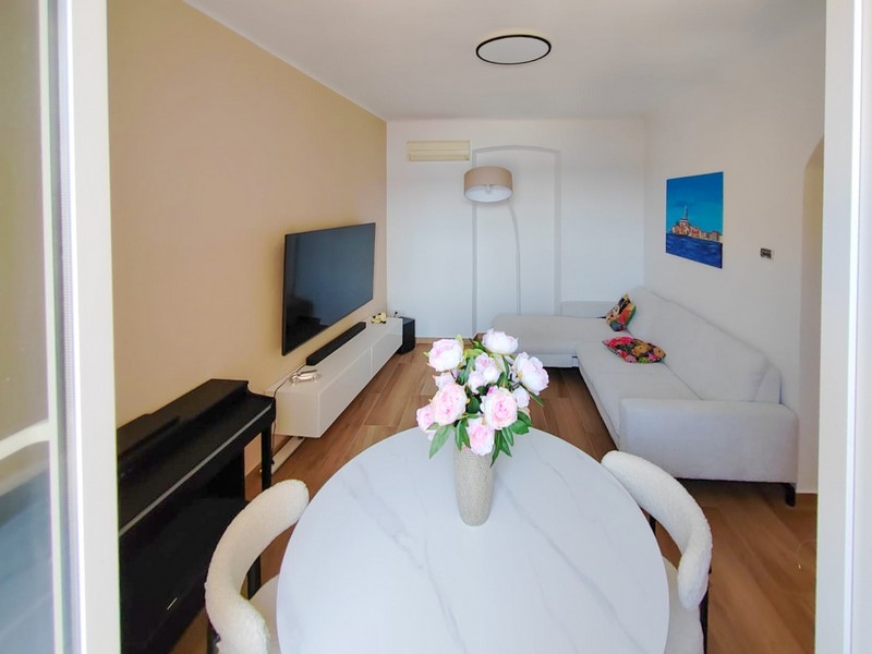 Jasny salon z sofą i stołem jadalnym