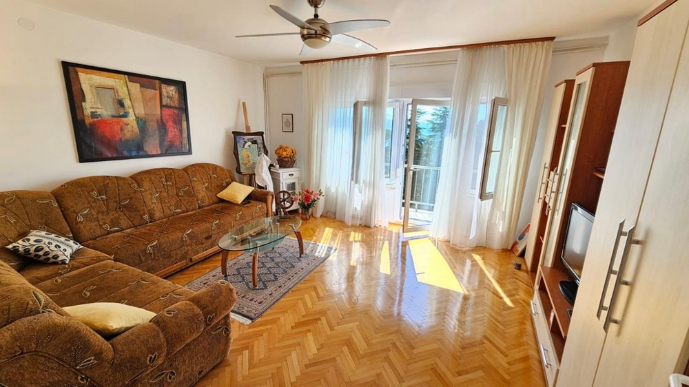 Jasny salon z sofą i wyjściem na balkon