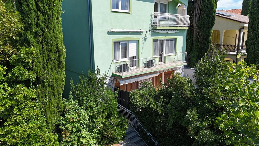 Budynek wielorodzinny z balkonem i zieloną elewacją