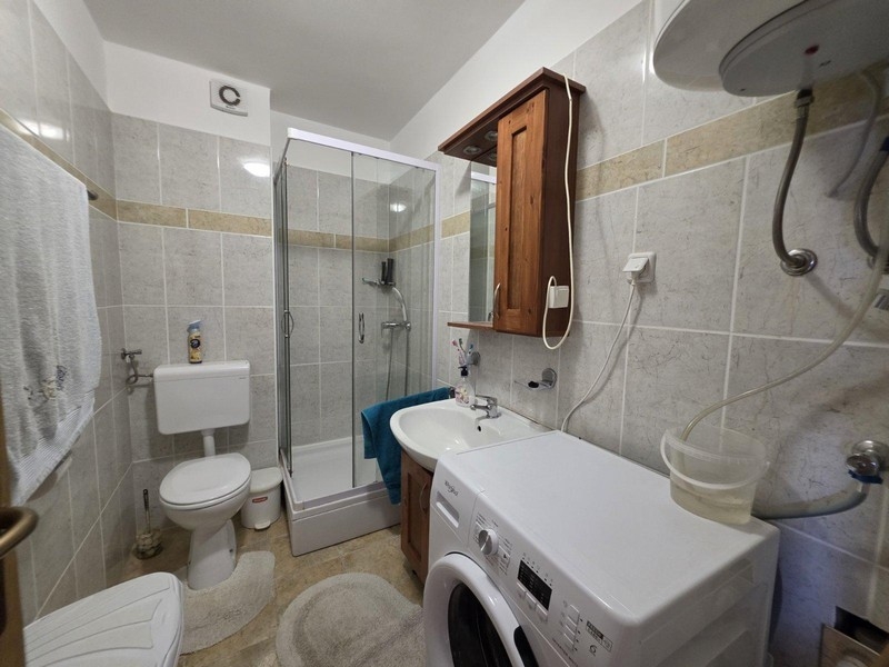 Łazienka z prysznicem, pralką i płytkami