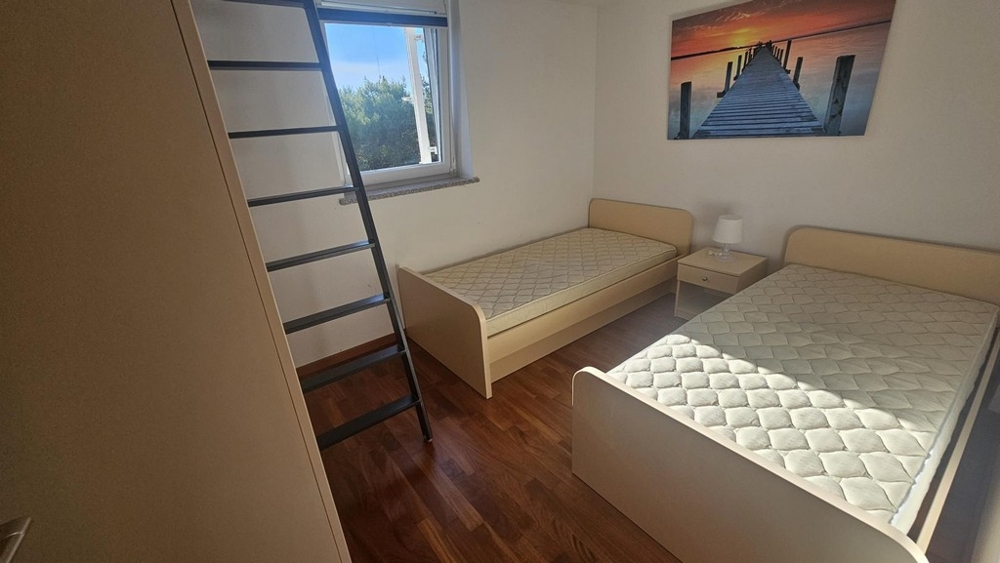 Pokój dziecięcy lub gościnny z dwoma pojedynczymi łóżkami i drabinką na galerię