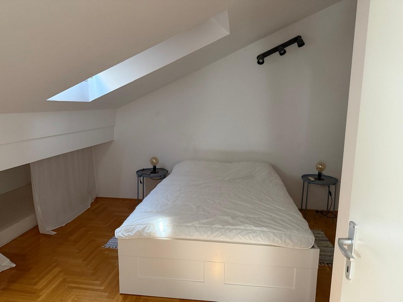 Sypialnia na poddaszu z łóżkiem i świetlikiem