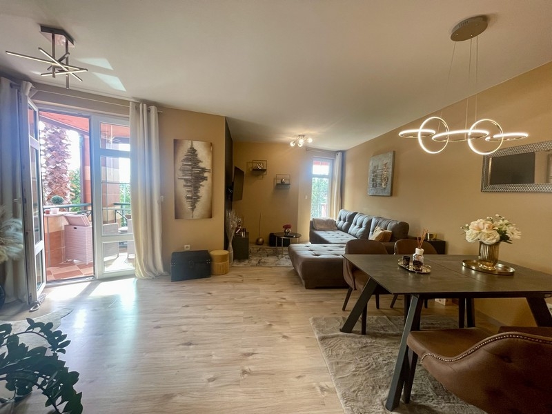 Jasny salon z jadalnią, sofą i wyjściem na taras