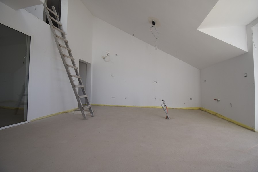 Otwarta przestrzeń na poddaszu z galerią i schodami drabinkowymi