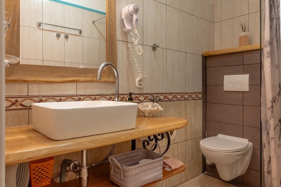 Łazienka z prysznicem i drewnianą toaletką