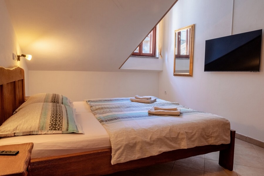 Sypialnia z łóżkiem małżeńskim i telewizorem ściennym