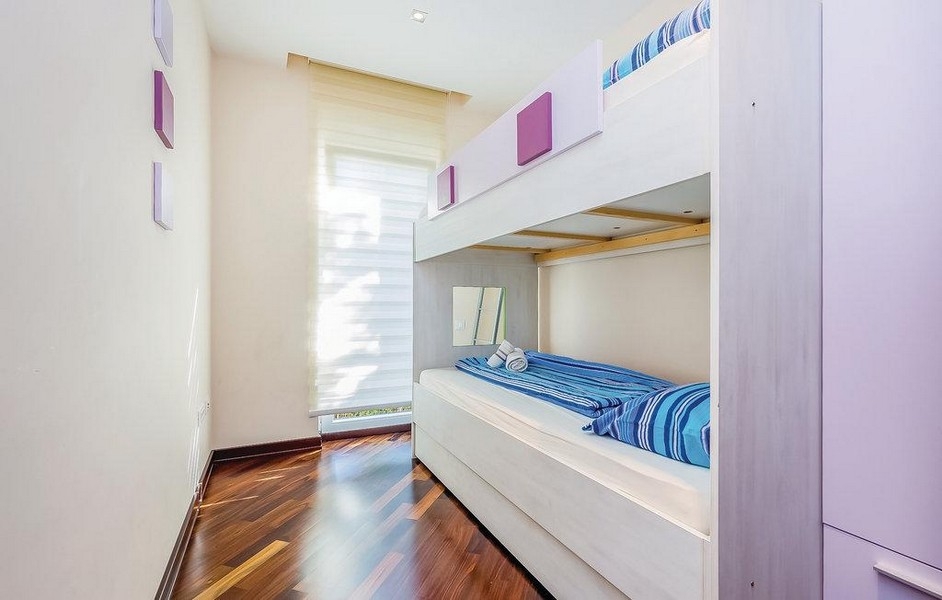 Pokój dziecięcy z łóżkiem piętrowym i drewnianą podłogą