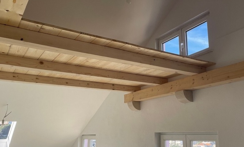 Drewniane belki i poziom galerii pod dachem