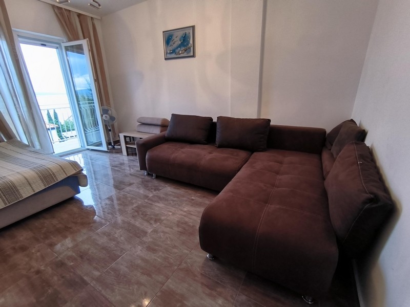 Sofa i wyjście na balkon z widokiem na morze