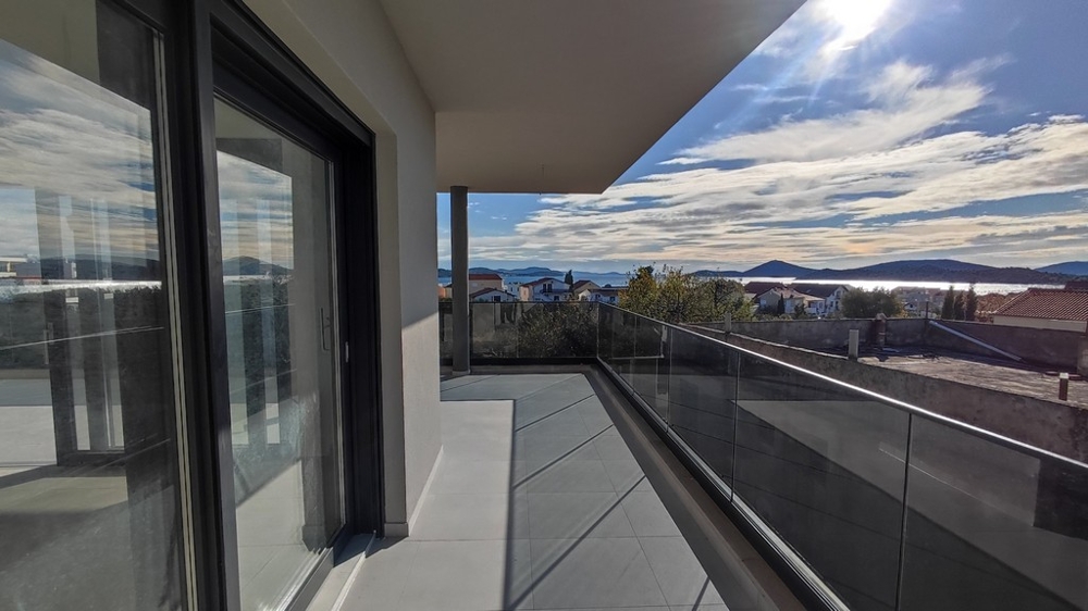 Balkon nowego mieszkania ze szklanymi balustradami i widokiem na morze