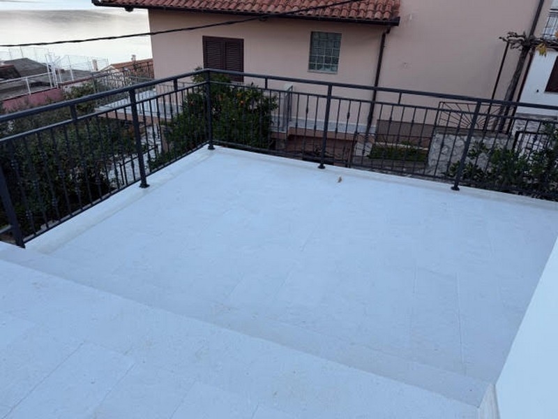 Taras z balustradą i widokiem na sąsiedni dom