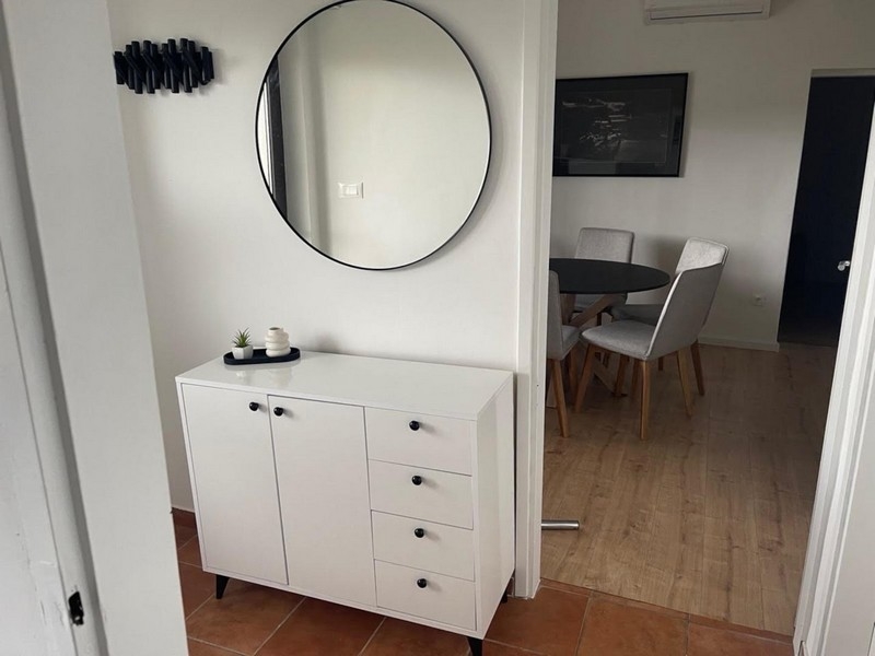 Przedpokój z białym kredensem i lustrem