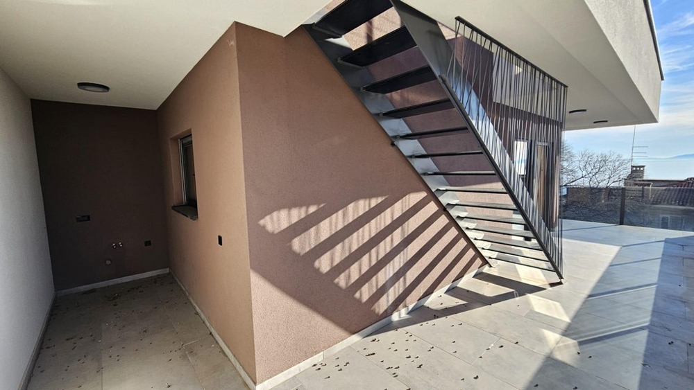 Zadaszony teren zewnętrzny z metalowymi schodami