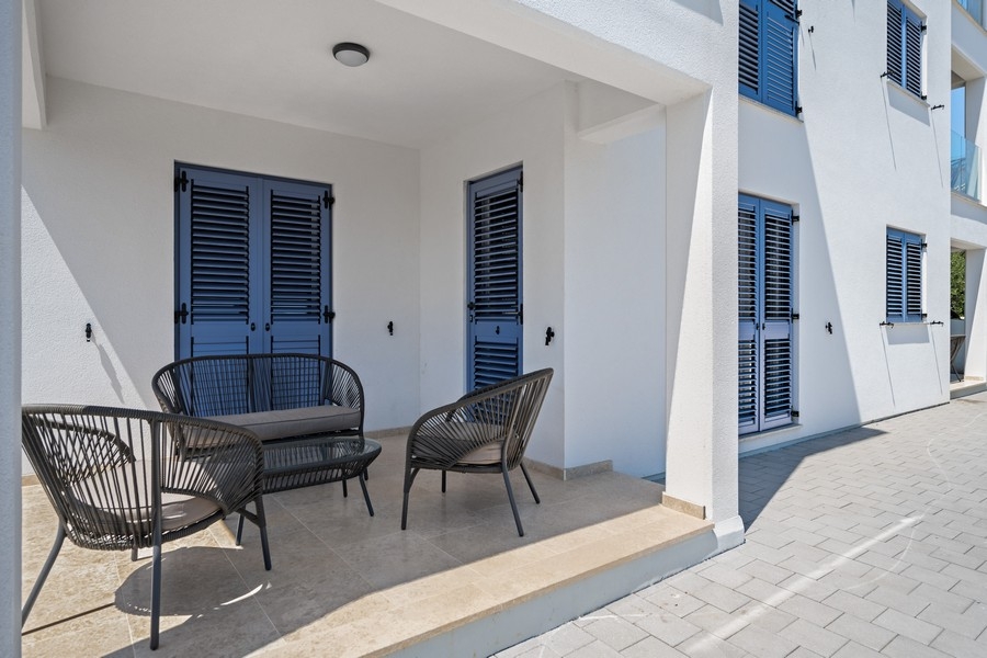 Zadaszony taras z miejscami do siedzenia i okiennicami